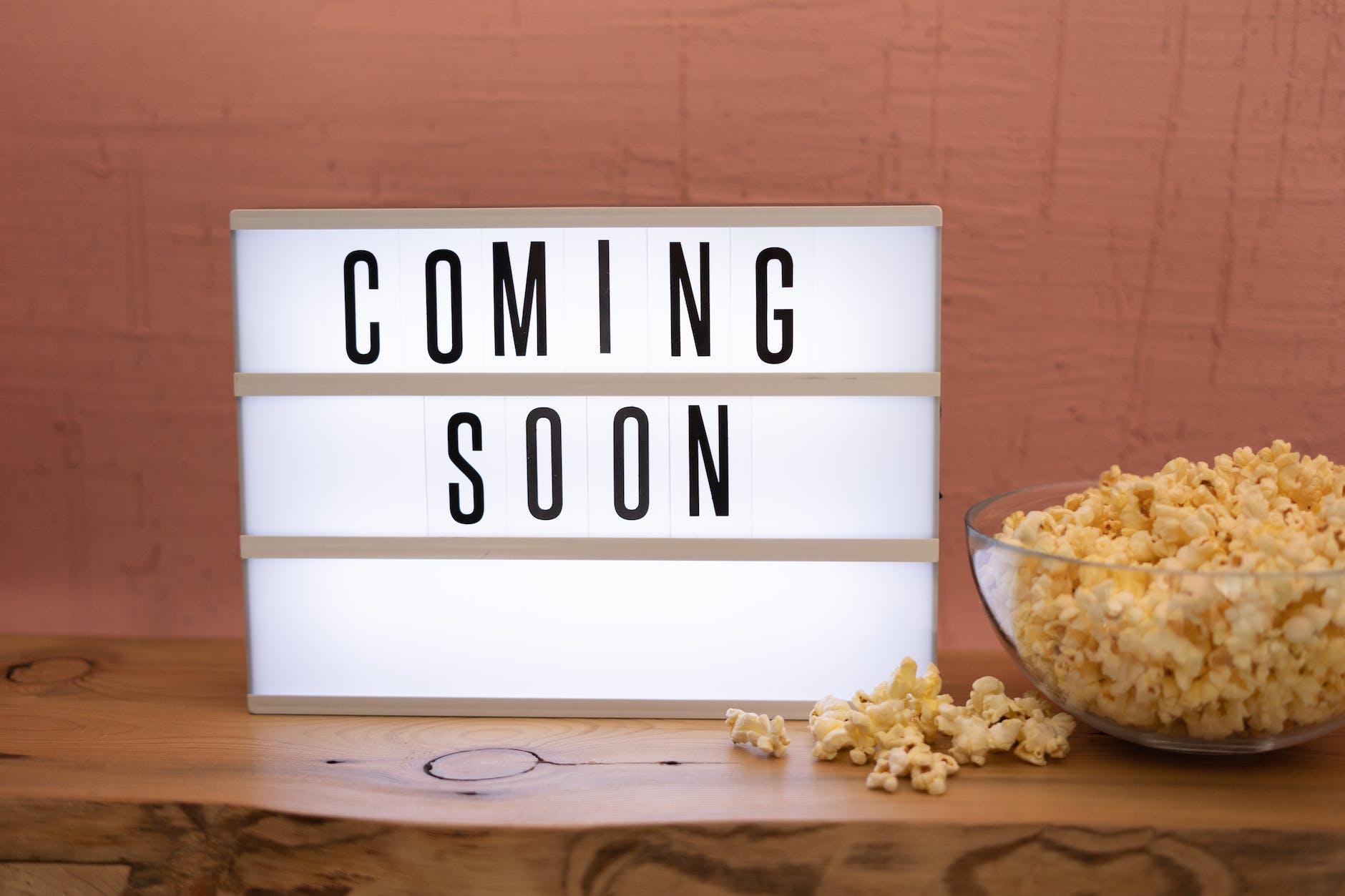 a coming soon sign by a bowl of popcorn